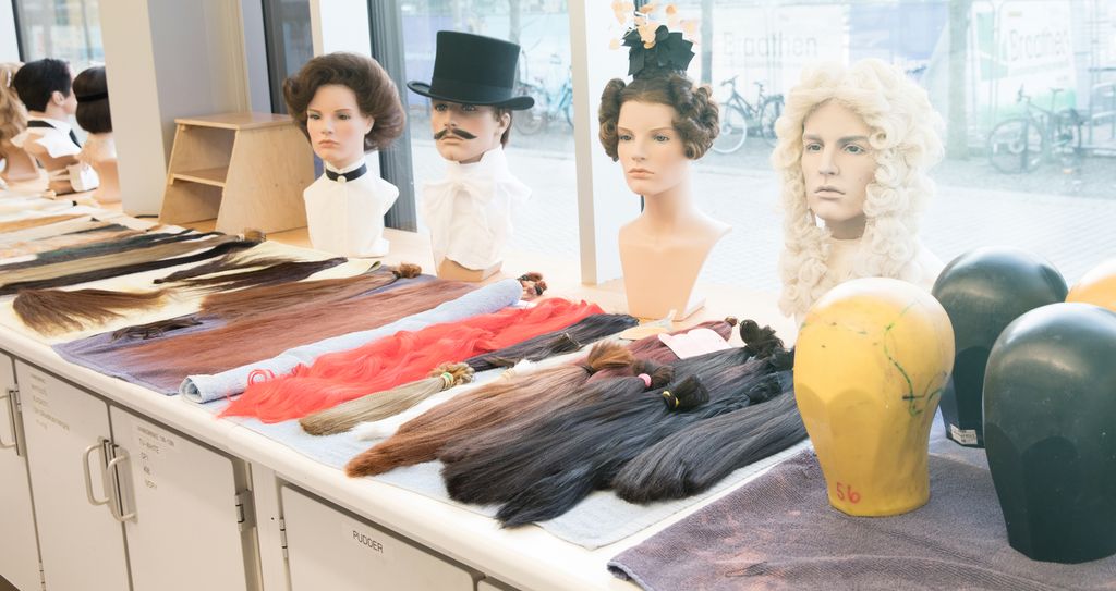 Dokkehovud med parykkar og hår i ulike fargar. Foto.