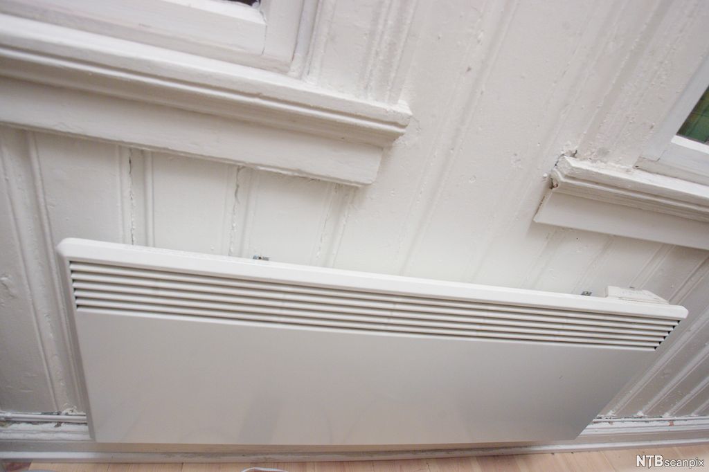 Panelovn under to vinduer. Foto.