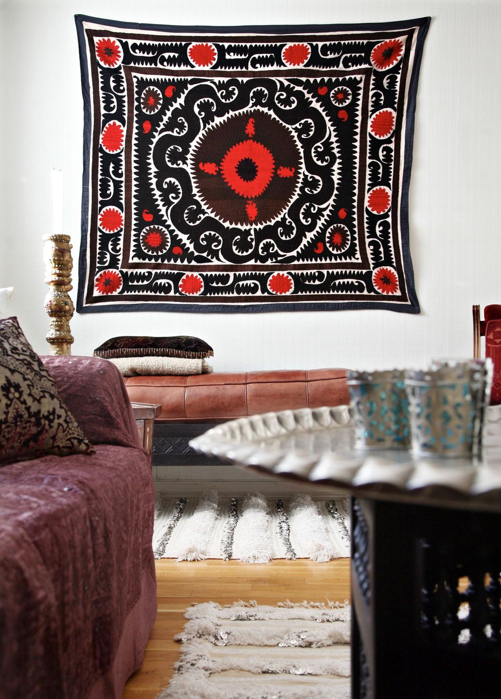 Stue med orientalske detaljar og eit markant teppe på fondveggen. Foto.