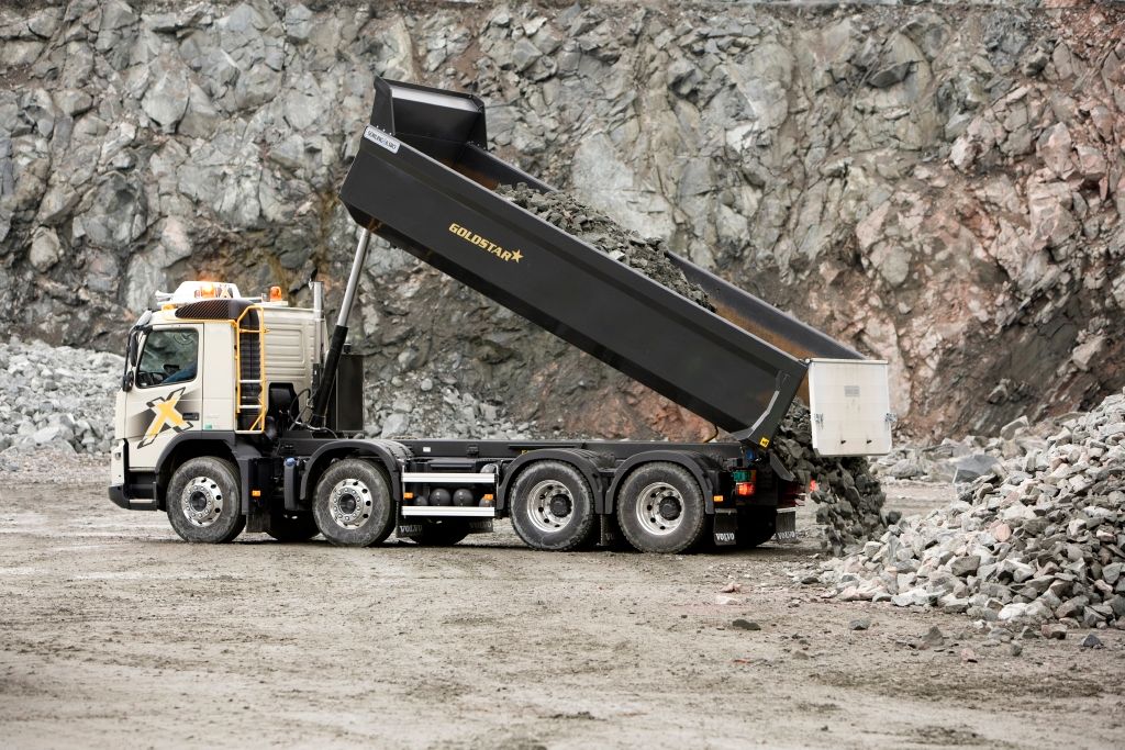 Bildet viser en tippbil som tipper masser på et anleggsområde.