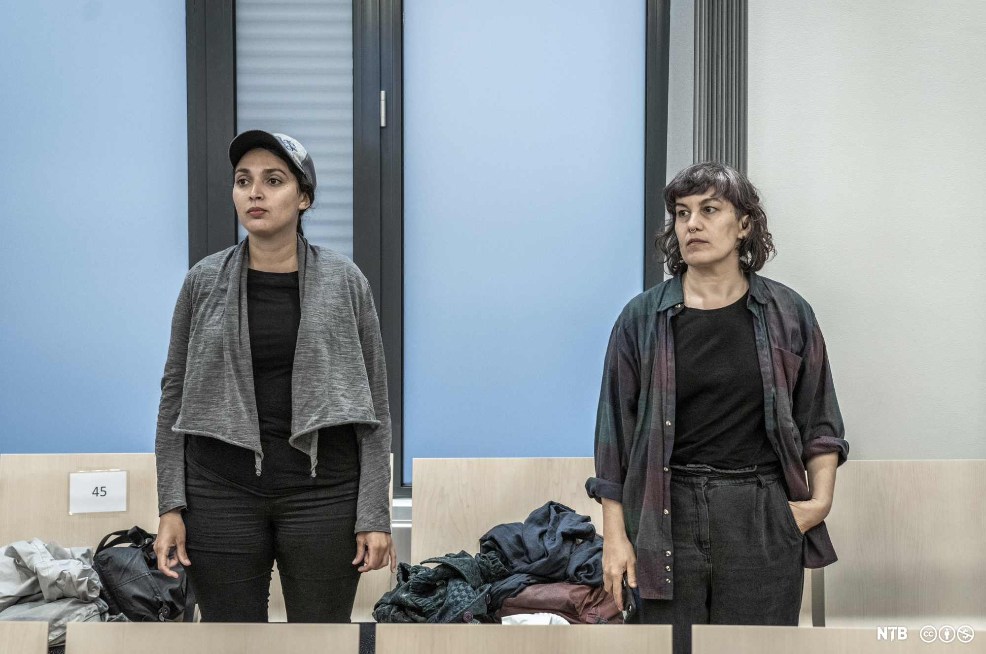 To damer står oppreiste i ein rettssal. Foto.