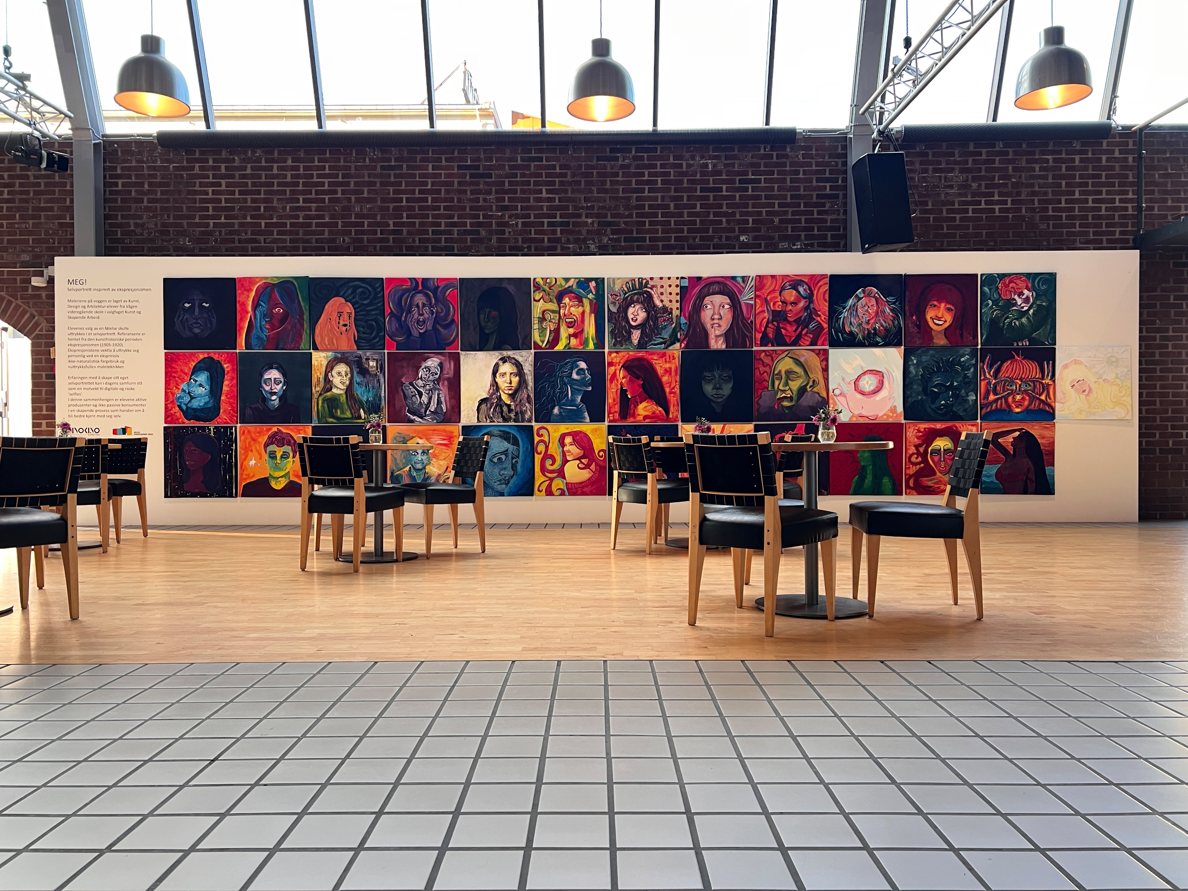 Gallerivegg med malerier i et kaféområde. Foto.