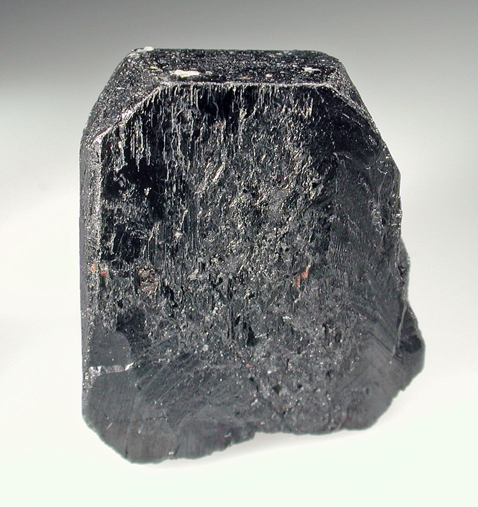 Tantalitt på kvit bakgrunn. Foto.