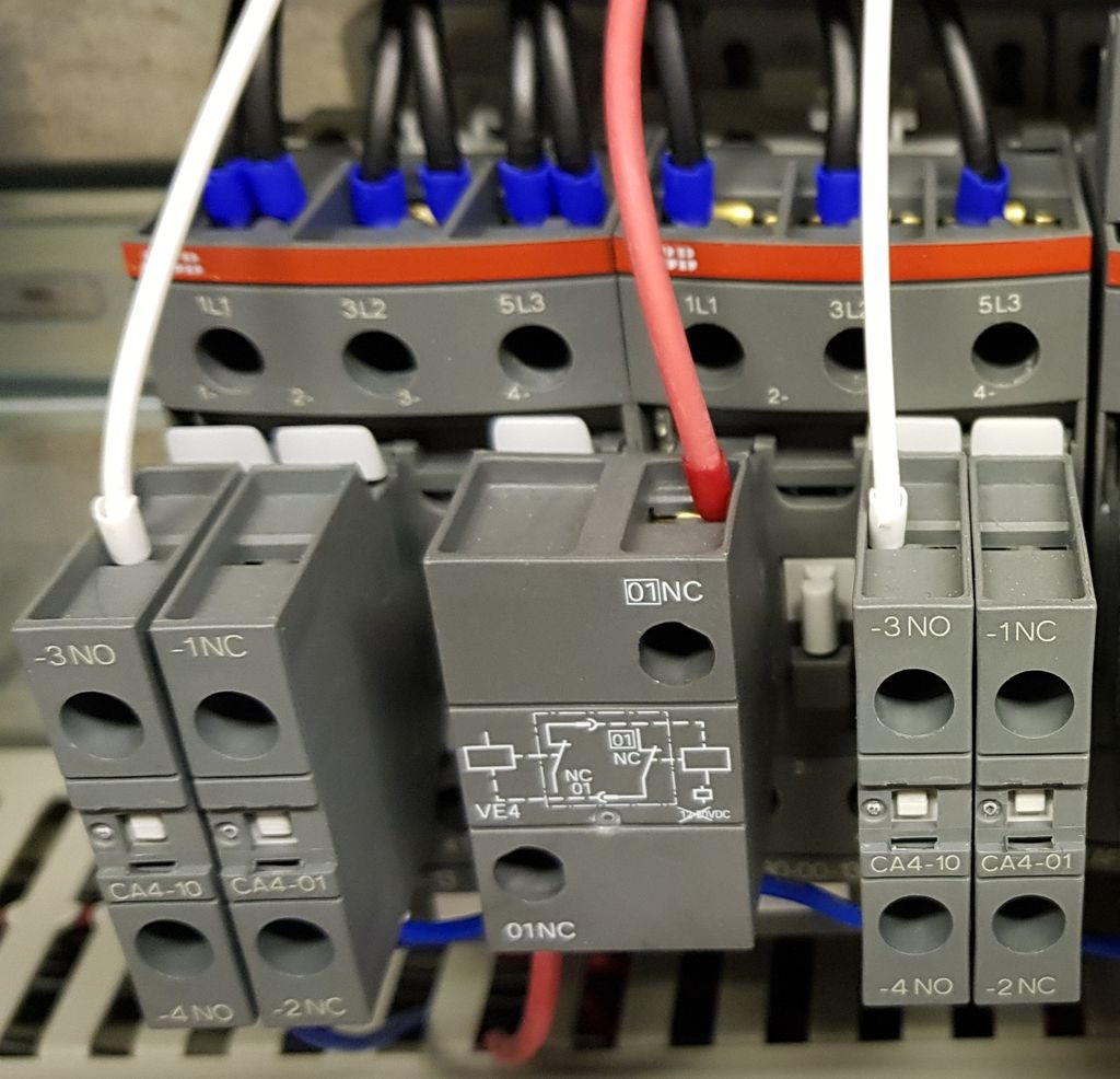 Biletet viser to kontaktorar med hjelpeblokker. Det er også kopla til nokre leidningar. Foto.