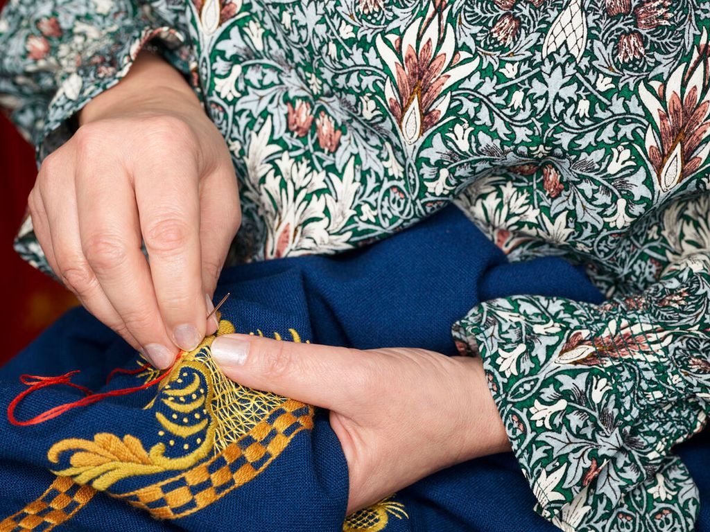 Hender broderer bunadsmønster. Foto.