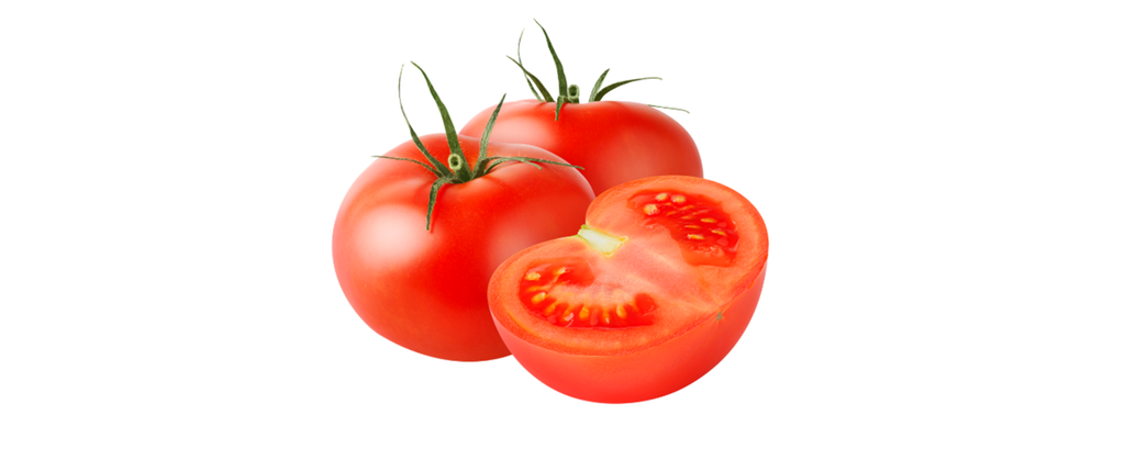 Tverrsnitt av en rød, rundt tomat. To hele tomater ligger i bakgrunnen. Foto.