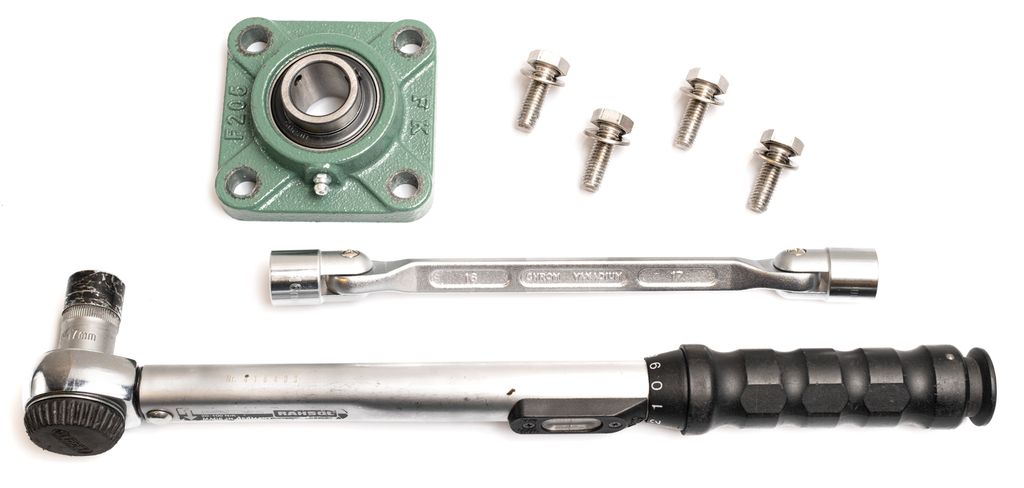 Ulike verktøy, skruer og et metallager. Foto.