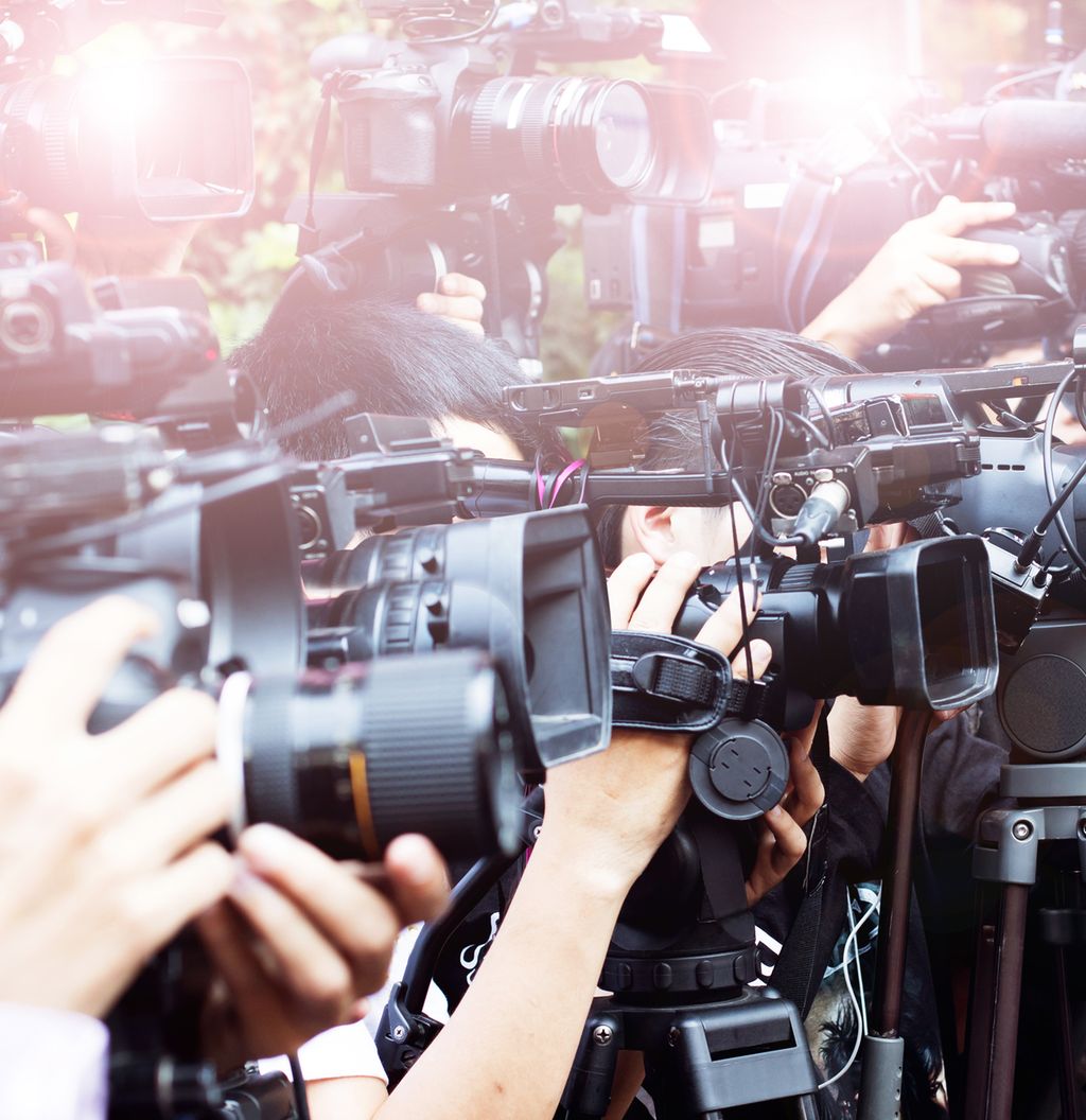 Eit stort koppel av journalistar med foto- og filmkamera knipsar i veg. Foto.