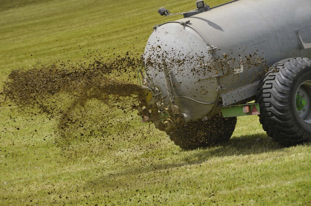 Gjødselspreder gjødsler grønt jorde. Foto.