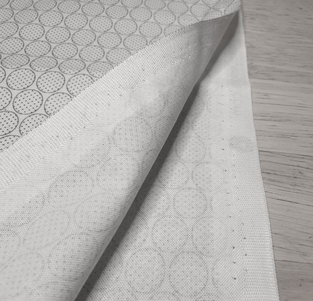 Fotografi av et tøystykke som er brettet slik at vi kan se jarekanten på vrangsiden av stoffet.