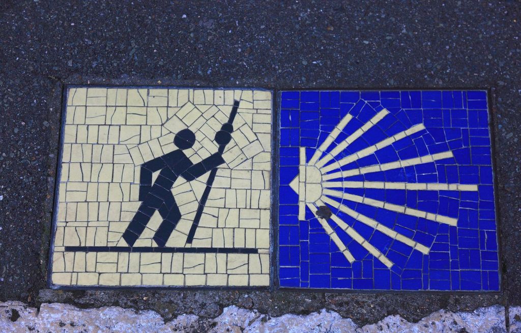 Mosaikk som består av to bilder. Det ene bildet har gul bakgrunn og viser en svart strekmann som går framoverlent med en lang stav. Det andre bildet har blå bakgrunn og viser noe som minner om ei strålende gul sol. Sola er hjerteformet og er til venstre i bildet, og strålene stråler ut mot høyre del av bildet. Foto.