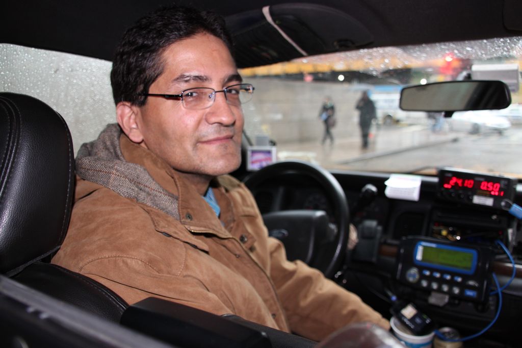 Ray is sitting behind the wheel in his cab. Photo.