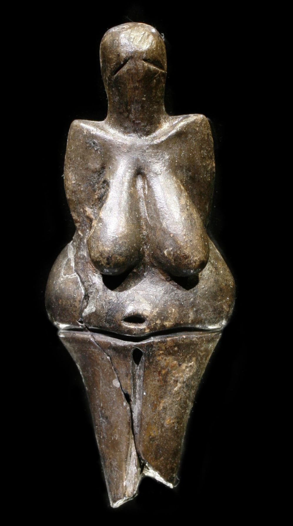 Stilisert kvinnefigur. Fyldig bryst og hofteparti. Foto.