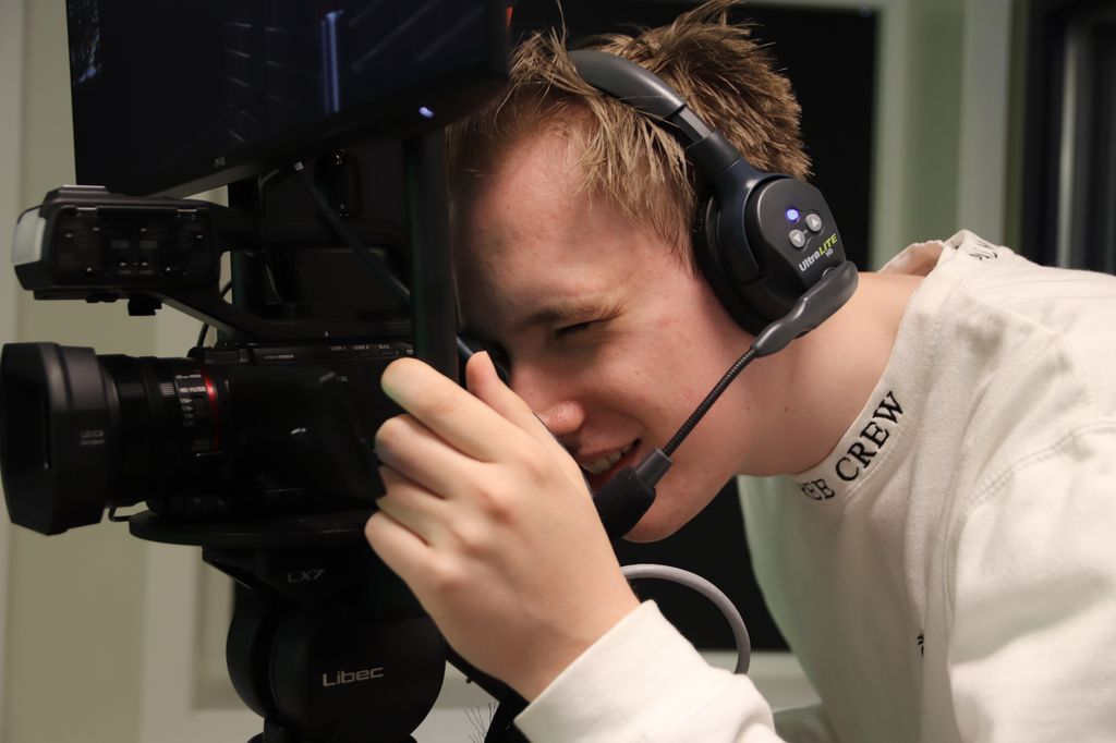 Ung mann ser i søker på tv-kamera. Foto.