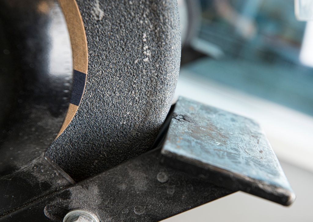 Anlegg og slipeskive på ein benkslipar. Foto.