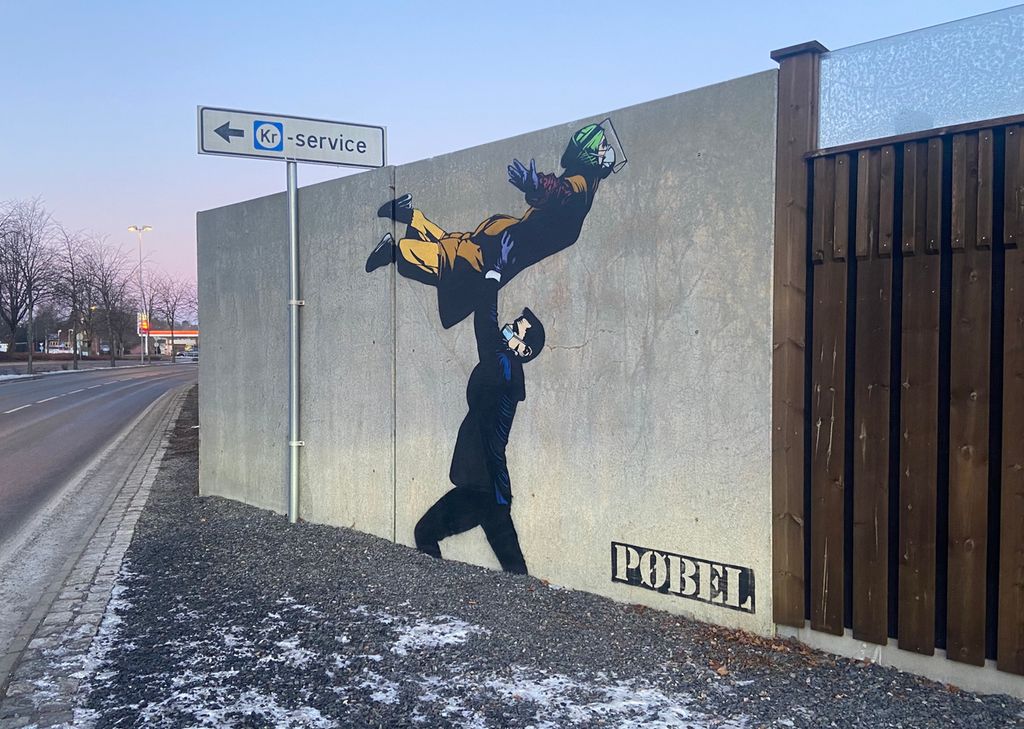 Gatekunst der helseminister Bent Høie løfter en helsearbeider med maske og beskyttelsesutstyr. Foto. 