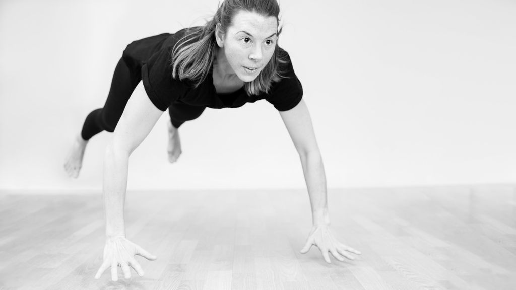 Jente hopper til armhevingsposisjon på gulvet. Foto.