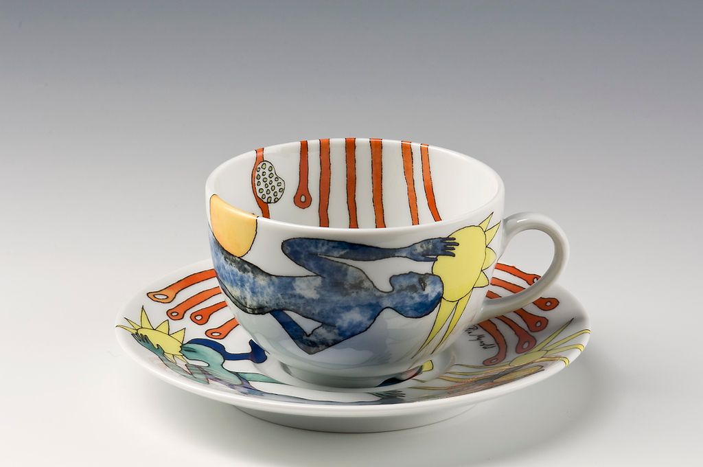 Kopp med skål i porselen med trykket dekor. Foto.