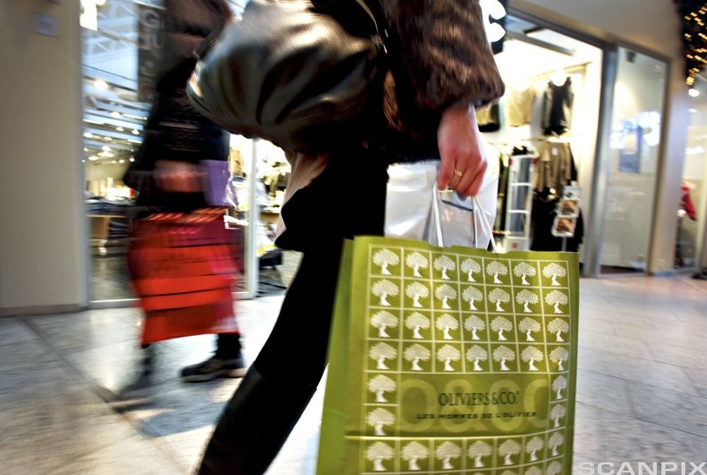 Person med flere handleposer på kjøpesenter. Foto. 