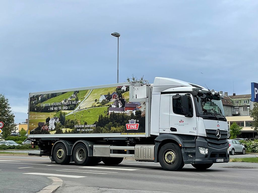Tine-lastebil med logo og teksten "Kanskje verdens fineste melk – på vei til deg –". Foto.