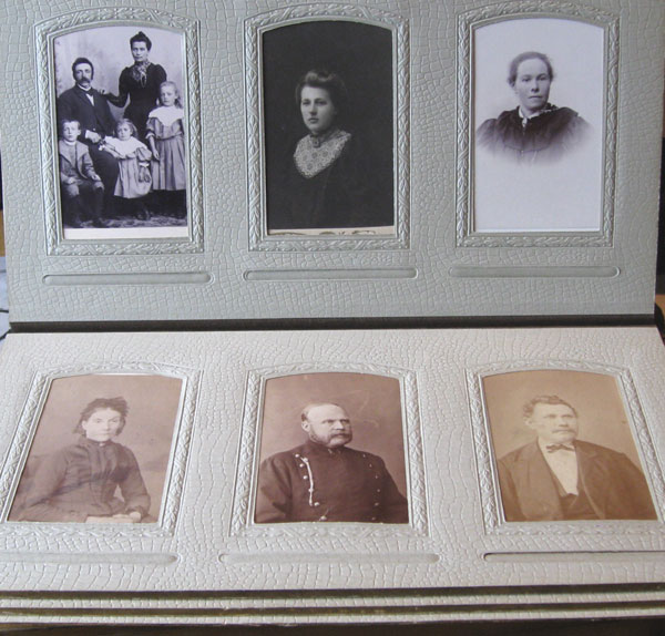 Tre svart-hvitt-fotografier i et fotoalbum. Det ene viser en mann, en kvinne og tre små barn. De to andre er portretter av kvinner. Ut fra klesstilen å dømme ser bildene ut til å være fra rundt 1900. Foto.