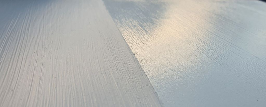 En overflate som er malt i samme farge, der venstre halvdel er mattere og høyre halvdel blankere. Foto.