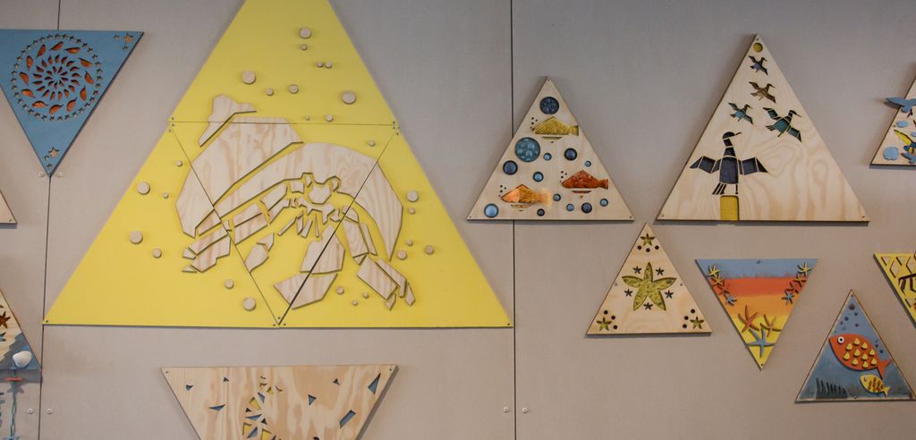 Bilder bestående av ulike materialer på en vegg. Foto.