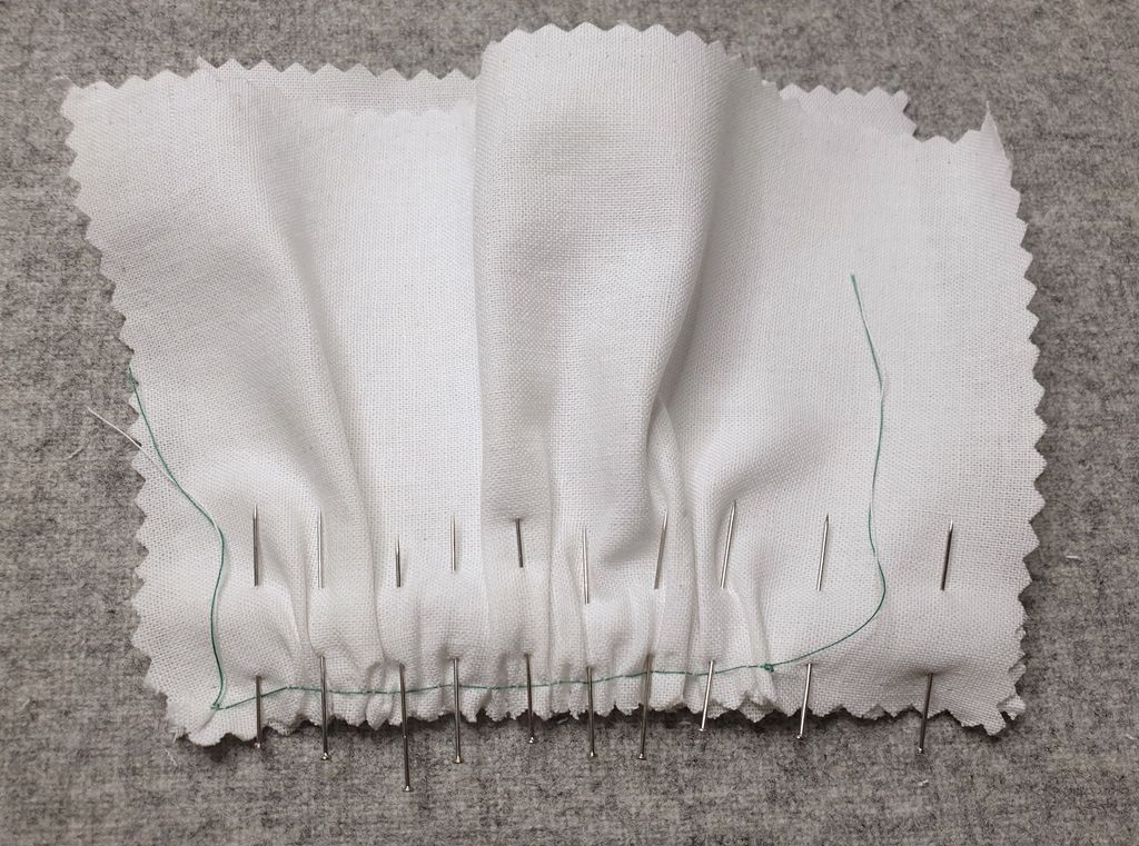 Fotografi av rynkesøm med knappenåler på tvers av sømmen.