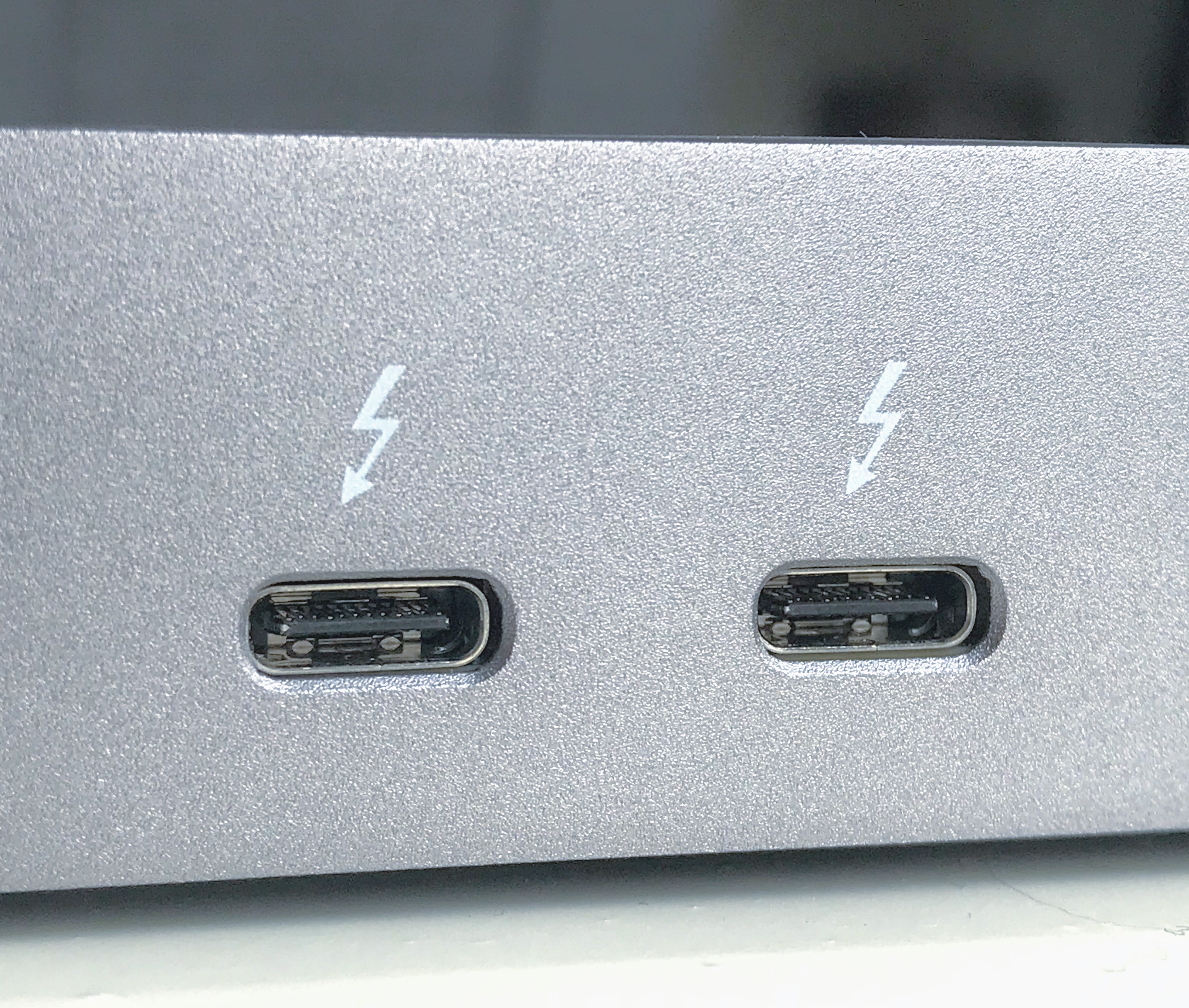 Nærbilde av to USB-C-kontakter på siden av en maskin. Begge er merket med et lynsymbol. Foto.