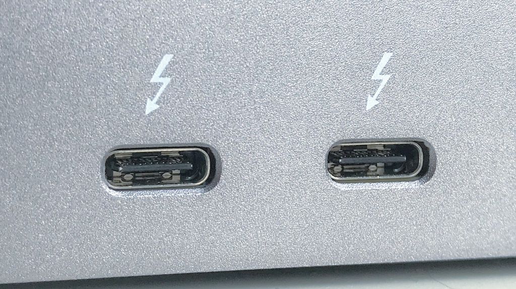 Nærbilde av to USB-C-kontakter på siden av en maskin. Begge er merket med et lynsymbol. Foto.