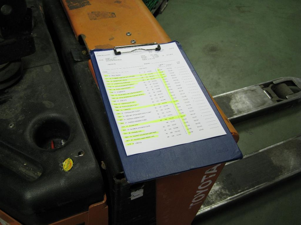 På bildet ser du et A4-ark med informasjon om hvilke varer som skal plukkes for en kunde. Listen ligger oppå en palletruck. Foto.
