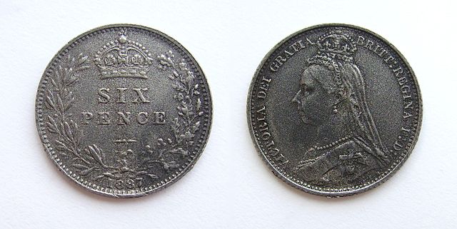 A photo of a British sixpence from 1897. The head of Queen Victoria is on one side of the coin. 