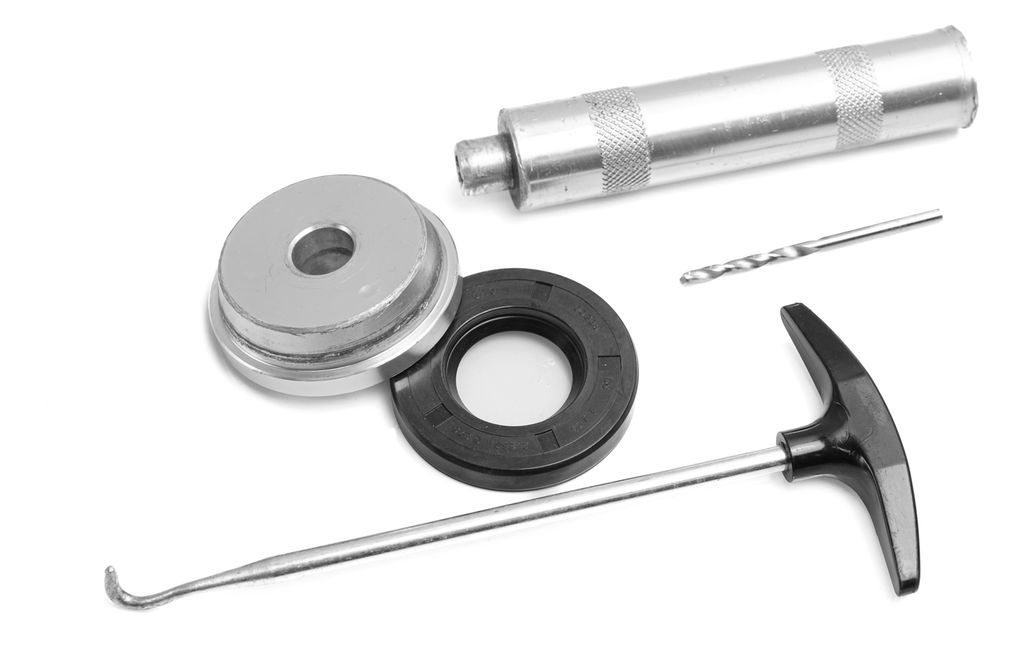 Dor, hylse, bor og trekkrok ligger ved siden av en svart gummiring. Foto.