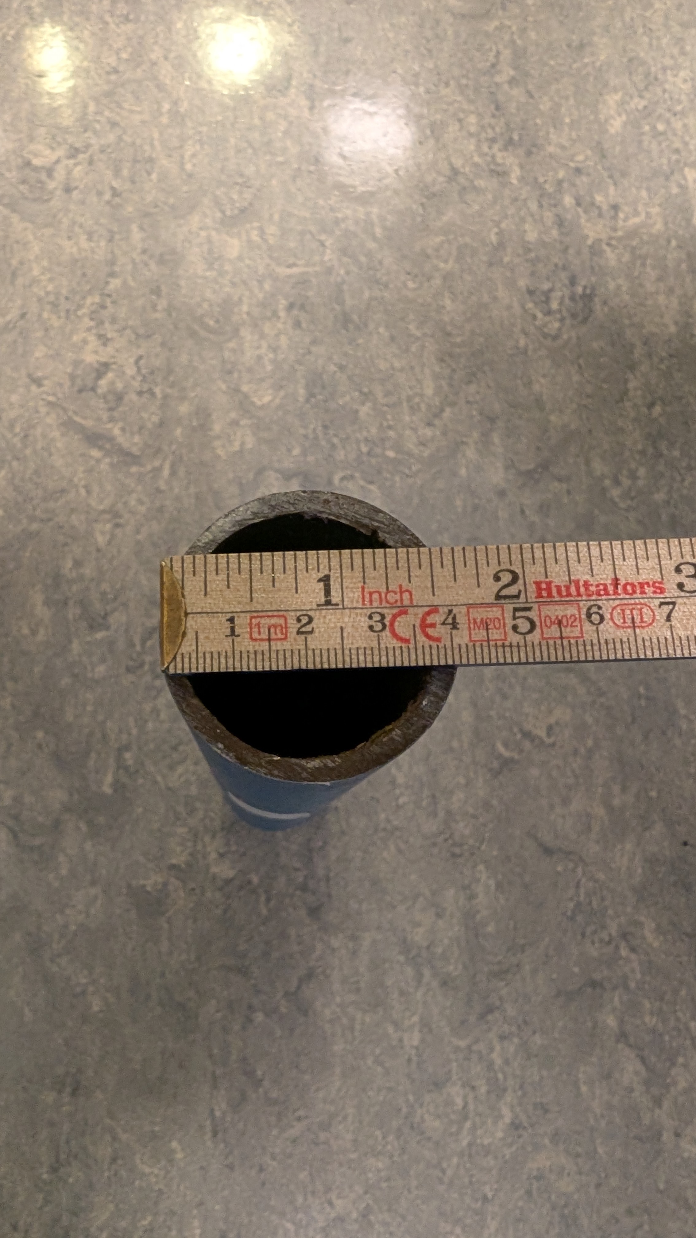 En meterstokk måler den ytre diameteren til et stålrør til å være omtrent 4,1 centimeter. Foto.