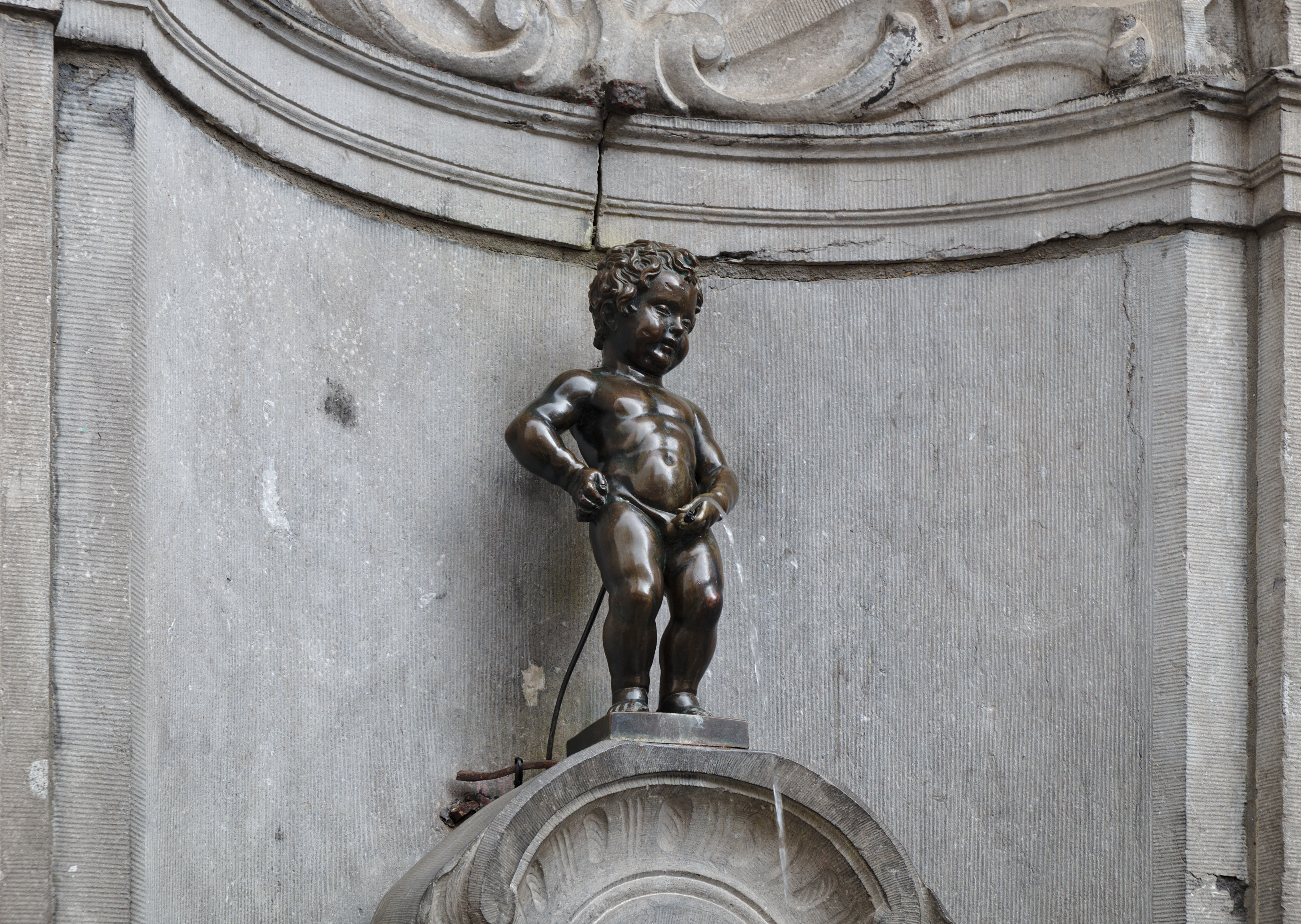 Statue av liten gutt som står og tisser. Foto