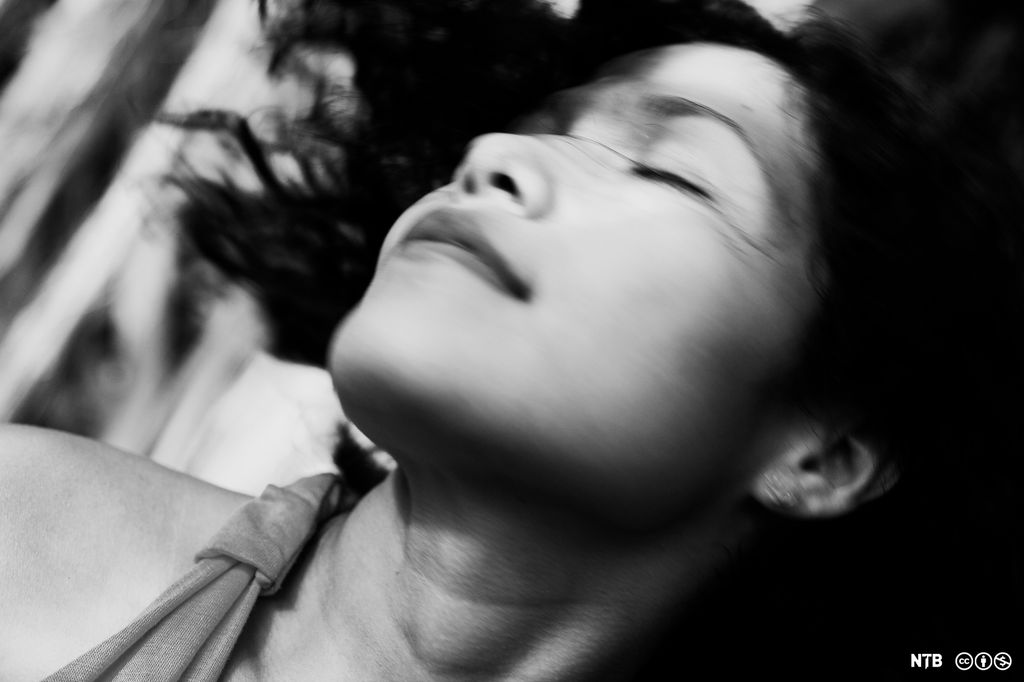 Kvinne rister på håret og ser fornøyd ut. Foto.