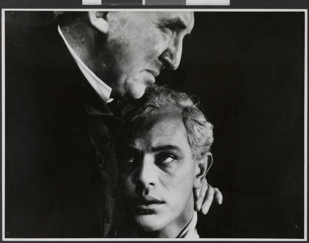 En ung gutt blir trøstet av en eldre mann. Begge ser fortvila ut. Foto.