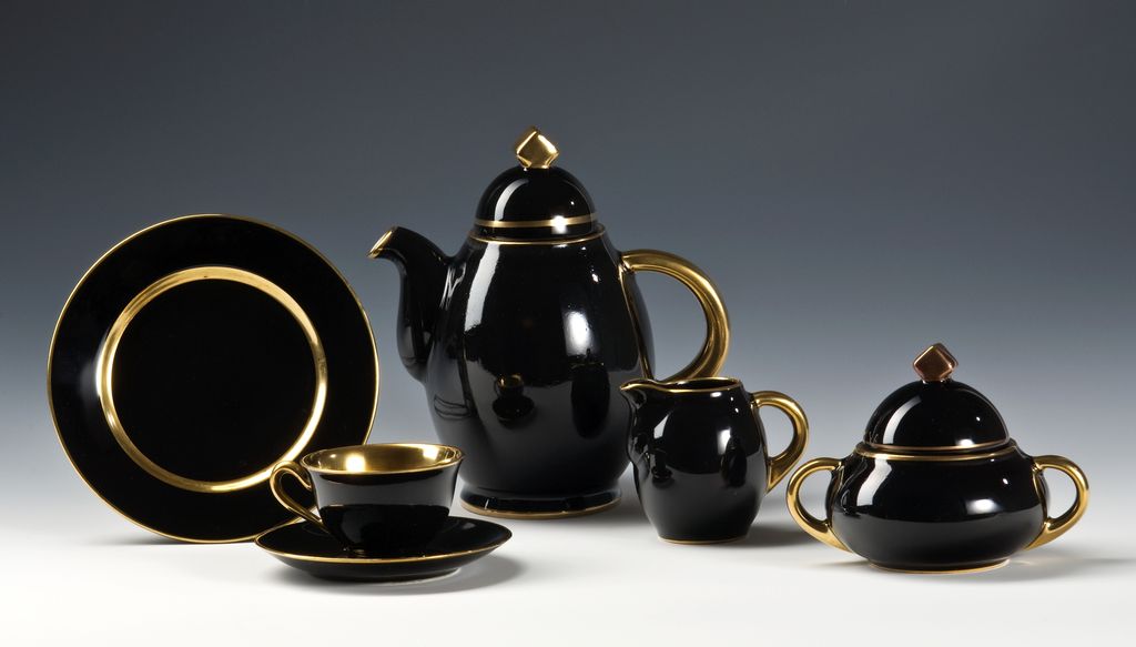 Svart servise med gulldekor. Foto.
