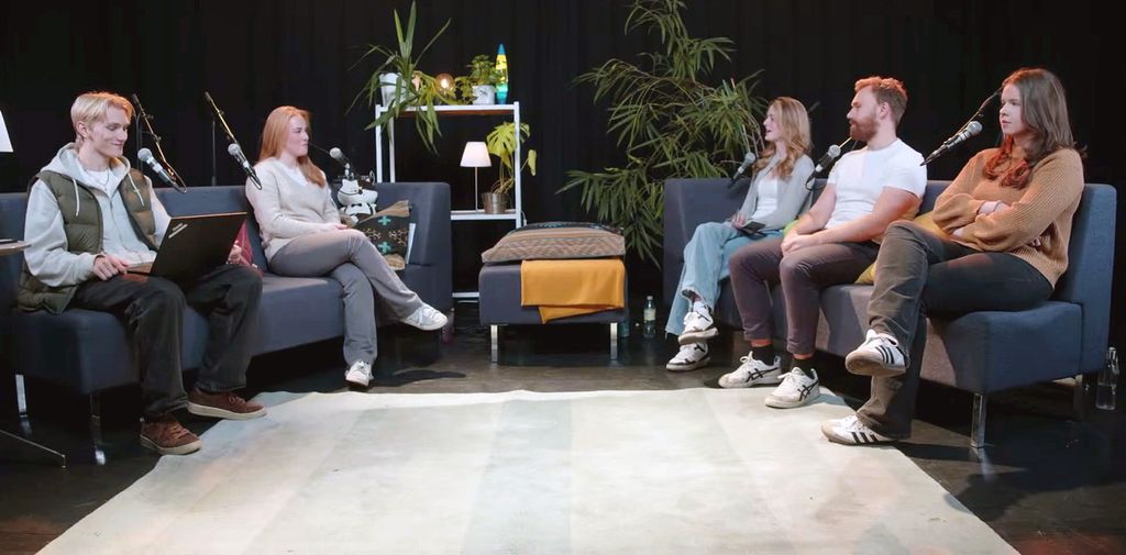 En opprigg av en debatt i studio. Fem elever sitter i to sofaer med mikrofoner satt opp bakfra. En av elevene har en bærbar datamaskin i fanget. Foto.