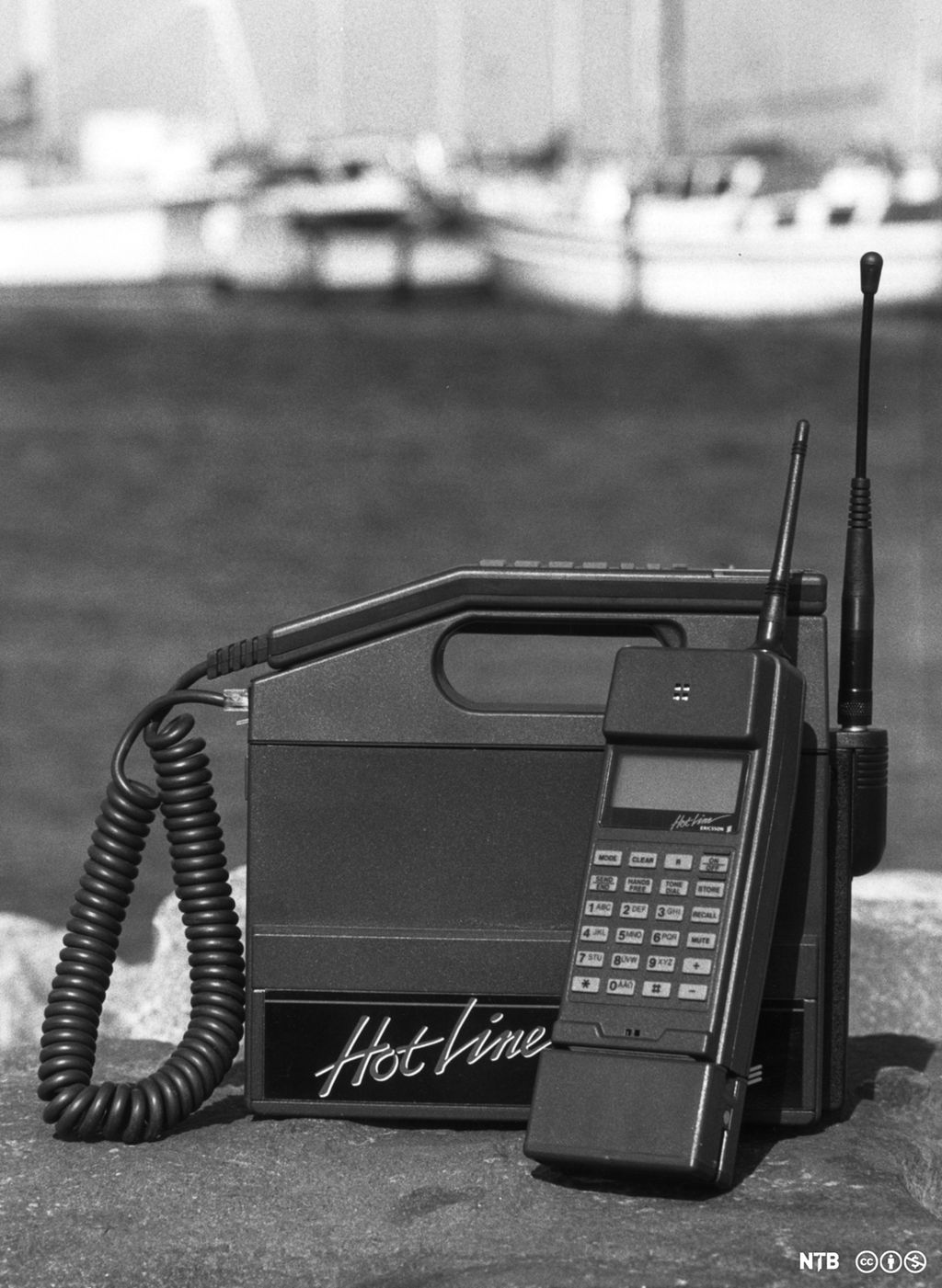 En gammel mobiltelefon formet som en boks med bærehåndtak. Foto.