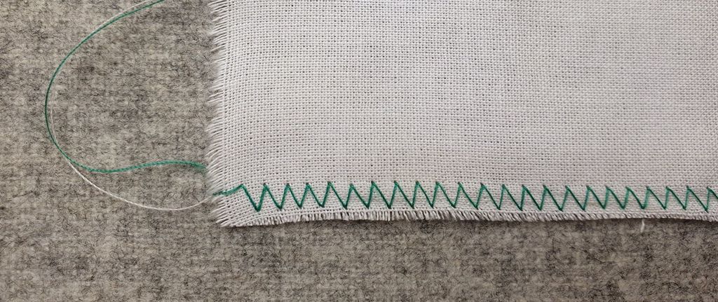 Fotografi av hvit prøvelapp med grønn sikksakksøm.