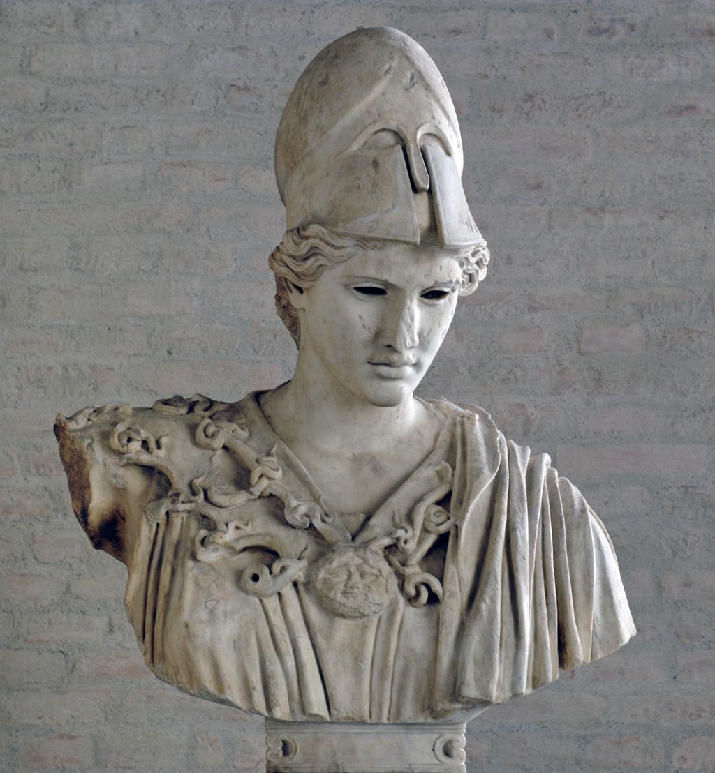Sculpture: Marble bust showing a woman wearing a helmet. Her clothes are draped, and she wears a large necklace. 