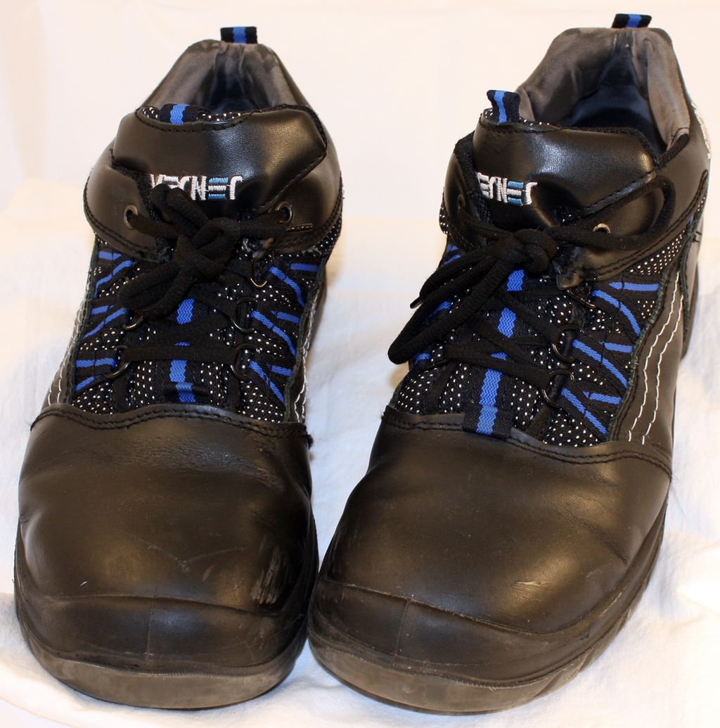 To svarte og blå sko med snøring. Det er ekstra god plass over tuppen på skoene, noe som antyder at de har vernetå. Foto.