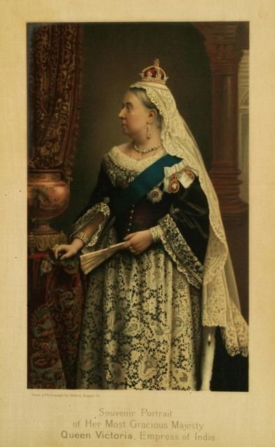 Photo of Queen Victoria. She is wearing a small crown, a white veil, and an elaborate dress. 