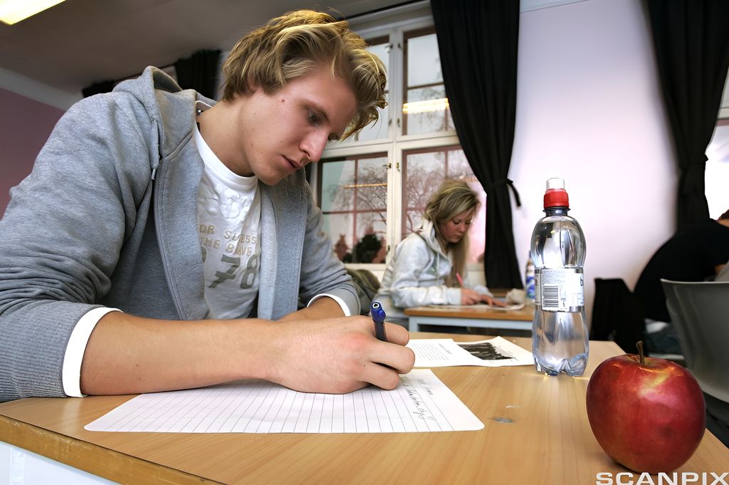 Ung mann skriver på en prøve. Foto.