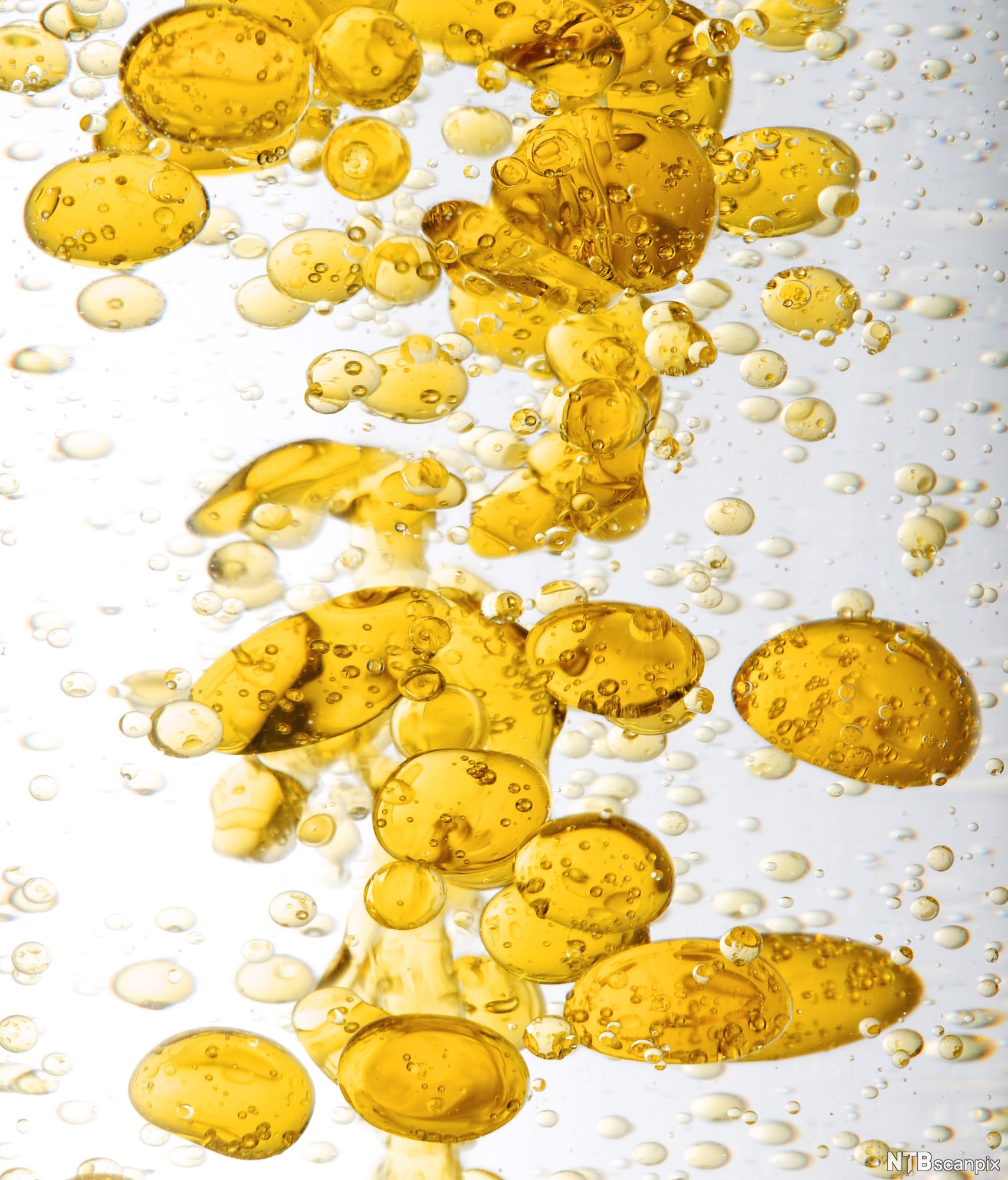 Oransje oljedråper i vann. Foto.