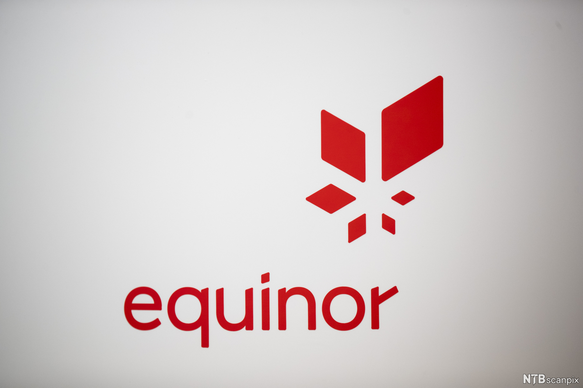 Seks raude firkantar i ulike storleikar spegla rundt eit senter, saman med teksten equinor. Logo.