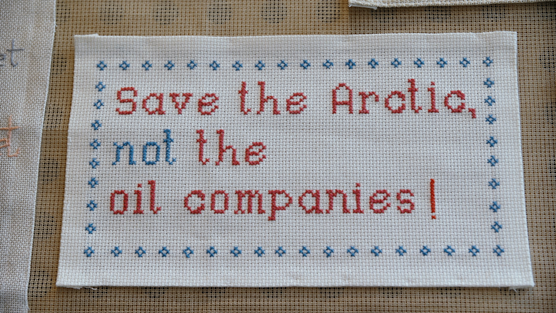 Broderi med teksten: "Save the Artic, not the oil companies!". Foto.