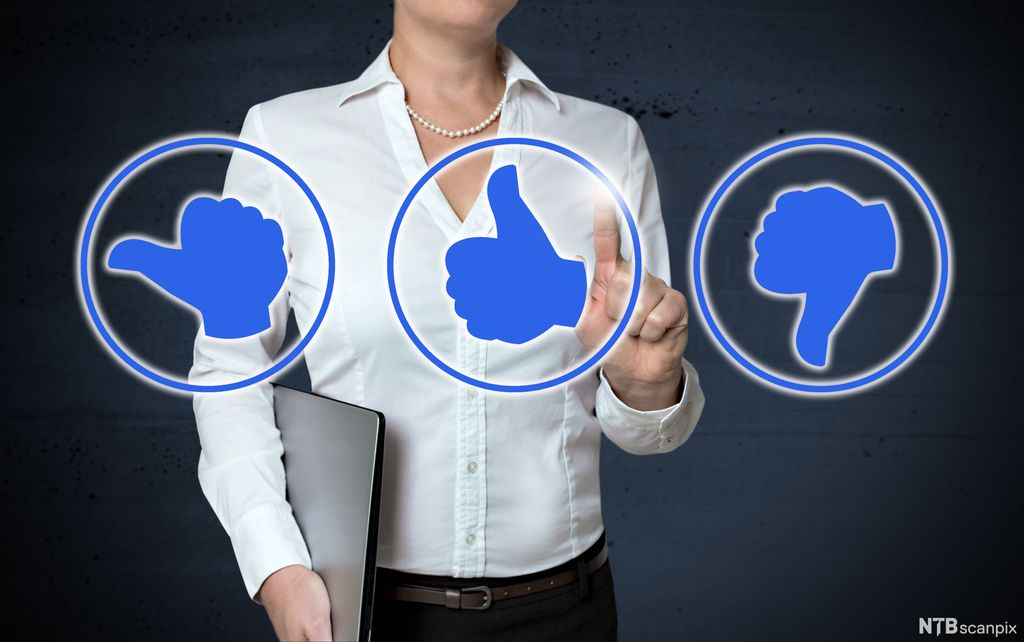 Kvinne med pc holder opp en pekefinger og trykker på illustrasjon av en tommel opp foran seg. Den er mellom symboler av tommel bortover og tommel ned. Manipulert foto.