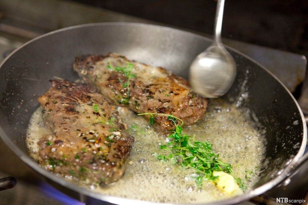 Biff med urter i stekepanne. Foto.